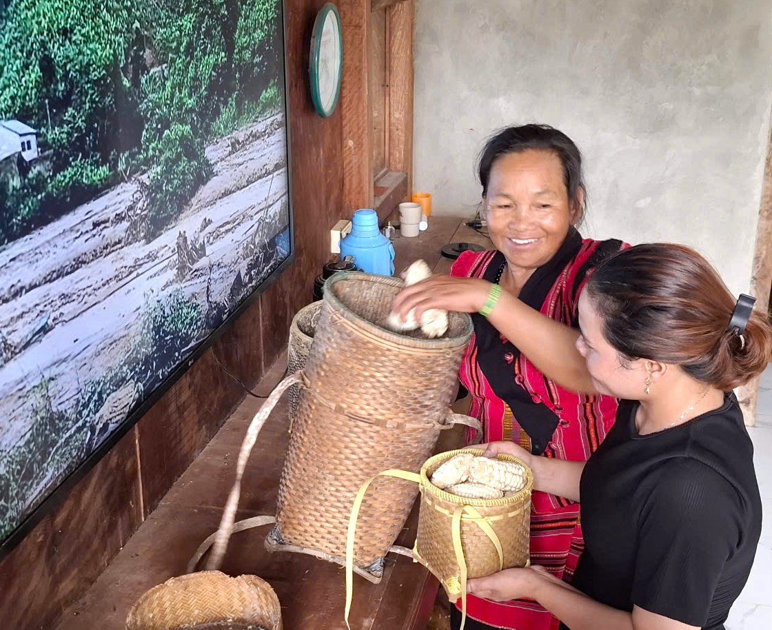 Mẹ Kăn Ling chia quà nông sản trồng được cho con gái Hồ Thị Pừng - Ảnh: L.H